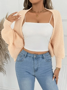 Detailaufnahme der grob gestrickten Strickjacke mit Fokus auf Ärmelstruktur und Bündchen