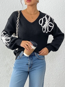 Women's black V-neck knit sweater featuring bold white 3D floral rope embroidery