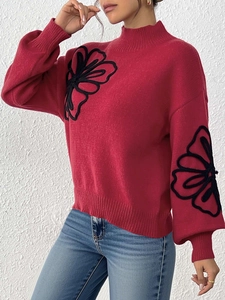 Detail shot of black floral embroidery on red lantern sleeve knitted sweater