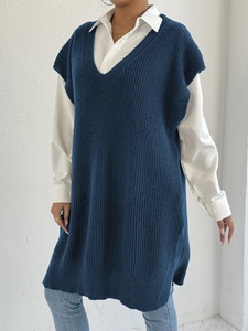 Dettaglio dello spacco laterale e dell'orlo in maglia di un gilet lungo blu con scollo a V