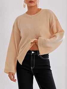 Details des lockeren apricotfarbenen Strickpullovers mit Rundhalsausschnitt und Rippbündchen