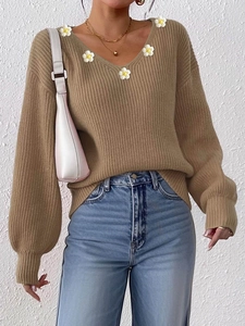 Detail von Strickpullover in Khaki mit V-Ausschnitt, Gänseblümchen und Rippenstruktur