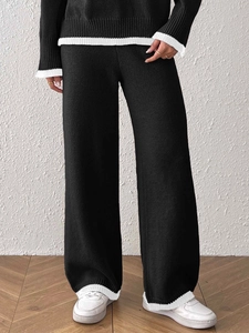 Completo in maglia nera da donna con bordi bianchi a contrasto e pantaloni larghi