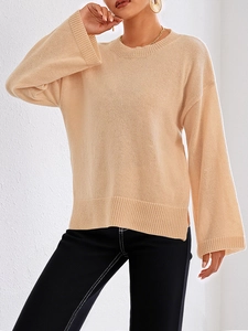 Detail eines apricotfarbenen Strickpullovers mit ausgestellten Ärmeln und Seitenschlitzen