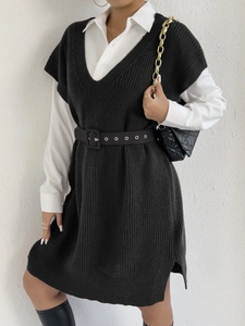 Dettaglio dell'abito in maglia nera a coste spesse con design a spacco laterale