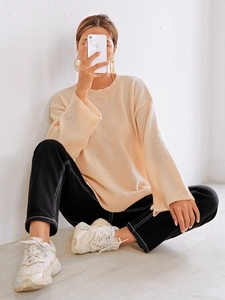 Detaillierte Nahaufnahme des beigen Strickpullovers mit Rippstruktur und weiten Ärmeln