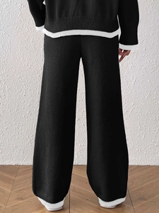 Vista posteriore di un set in maglia da donna con pantaloni neri larghi e maglione
