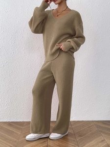 Detail of camel knit V-neck sweater and high-waisted wide-leg pants texture and drape