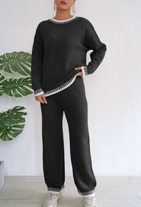 Détail de l'ensemble en maille noire avec bords côtelés rayés aux manches et pantalon