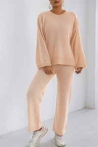 Close-up of the textured knit fabric on a peach-colored sweater and wide-leg lounge pants