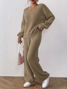 Close-up showing the soft knitted texture of khaki V-neck sweater and wide-leg trousers set