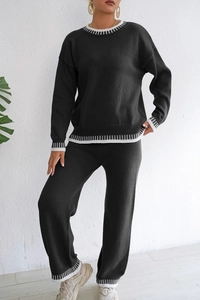Détail de l'ensemble en tricot gris foncé avec rayures blanches aux poignets et à l'ourlet