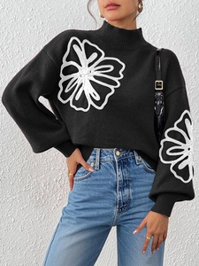 Detail view of mock-neck knit sweater featuring large white floral embroidery and lantern sleeves