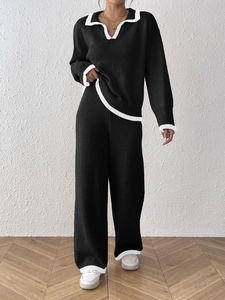Détail d'un pull en maille noir avec col et ourlet blancs contrastés pour un ensemble chic