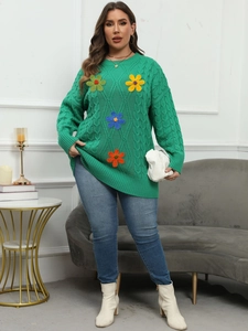 Detailed close-up of grass green cable knit sweater with colorful 3D crochet flowers