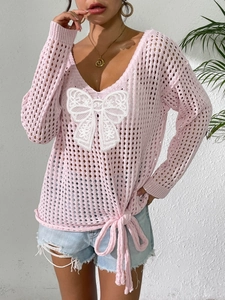 Detail von rosa Strickoberteil mit weißer Spitzenschleife und verstellbarem Kordelzug