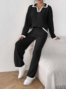 Détail de l'ensemble noir en maille avec rayures blanches sur le col Polo et le pantalon