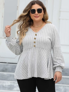 Detail of grey V-neck ribbed top featuring decorative gold buttons and soft knit texture