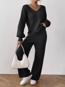 Detail view of black knit V-neck top and wide-leg trousers set with ribbed texture