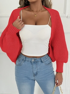 Nahaufnahme der hellroten Grobstrickjacke mit Wabenmuster an einem weiblichen Model