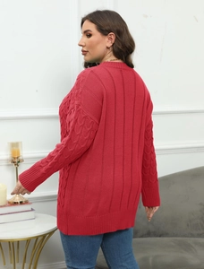 Detail of red cable-knit plus size sweater showing texture and relaxed fit on model