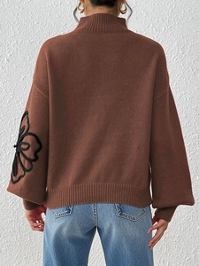 Brown high neck sweater with black floral embroidery on lantern sleeves shown from behind