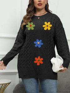 Detail of dark grey cable knit sweater featuring colorful crochet floral appliques