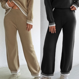 Détail du pantalon en tricot à taille haute avec ourlet côtelé et rayures blanches contrastées