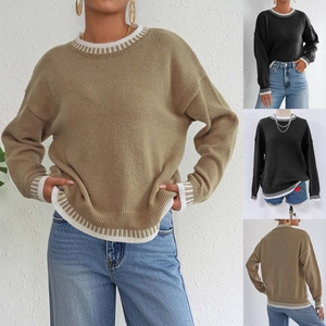 Dettaglio delle strisce a contrasto sullo scollo e sui polsini di questo maglione