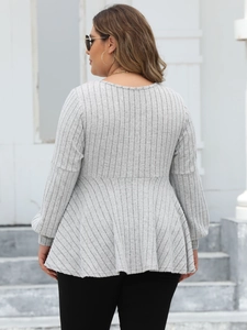 Detail of grey ribbed knit texture and stylish peplum hem on long sleeve plus size top
