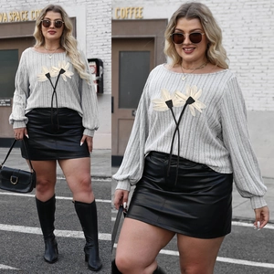 Plus size grey ribbed knit top with white floral applique and black leather mini skirt