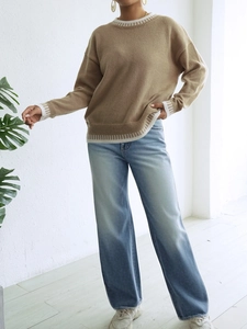 Dettaglio dei polsini e dell'orlo a righe a contrasto su un maglione in maglia kaki casual