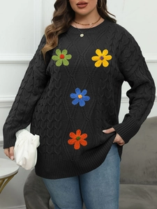 Detail of colorful hand-knitted floral embroidery on black cable knit sweater