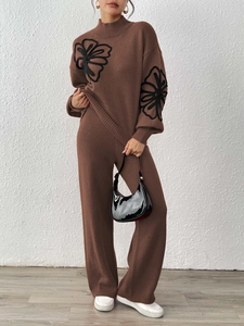 Detailed view of floral embroidery on a dark brown knit sweater and wide-leg pants set