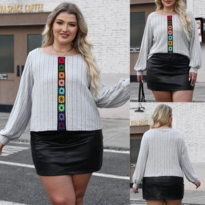 Detail of plus size grey ribbed knit top featuring colorful crochet patchwork and embroidery