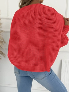 Detailansicht eines roten Grobstrickpullovers mit Wabenmuster und gerippten Bündchen