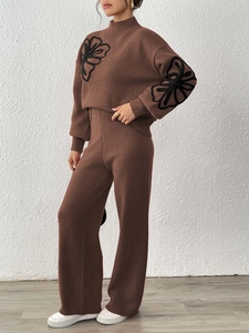 Detail of dark brown knit set featuring black ribbon floral embroidery on the sweater