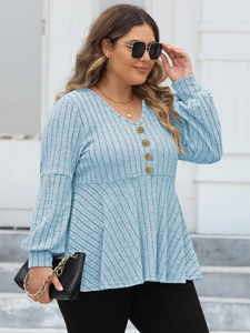 Close-up of golden buttons and ribbed texture on plus size light blue V-neck knit top