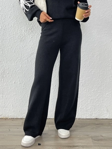 Dettaglio del set in maglia nera con ricamo floreale bianco sulle maniche lunghe