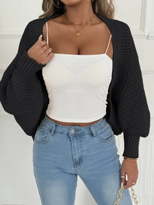 Detail der schwarzen Strickjacke mit Hohlmaschenstruktur und Puffärmel-Design
