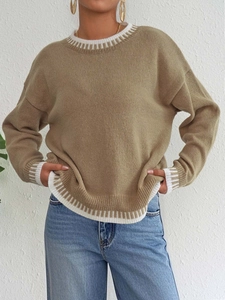 Dettaglio del maglione in maglia kaki con strisce bianche su scollo e polsini