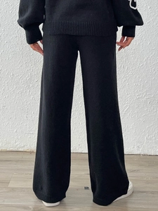 Vista posteriore del set in maglia nera con pantaloni larghi casual e top a maniche lunghe