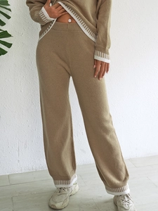 Détail d'un ensemble en tricot avec poignets côtelés rayés blancs et tissu kaki doux
