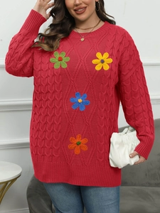 Detail of vibrant red cable knit sweater with colorful 3D floral embroidery appliques