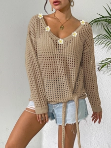 Detail view of khaki crochet knit V-neck sweater with daisy patches and lace-up bow