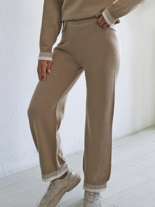 Détail du pantalon en tricot kaki avec poignets côtelés à rayures blanches et texture douce
