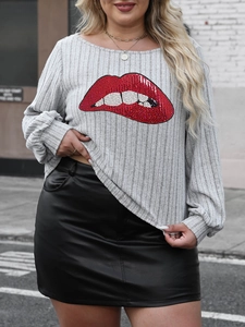 Detail of grey ribbed long sleeve top with sparkling red sequin lips and leather skirt