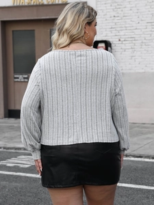 Plus size grey ribbed knit top and black leather mini skirt outfit view from behind