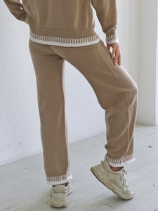 Vue détaillée du pantalon en maille kaki avec des bords-côtes rayés blancs sur l'ourlet
