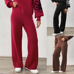 Detailed knit texture of wide-leg trousers and floral pattern on sweater sleeve
